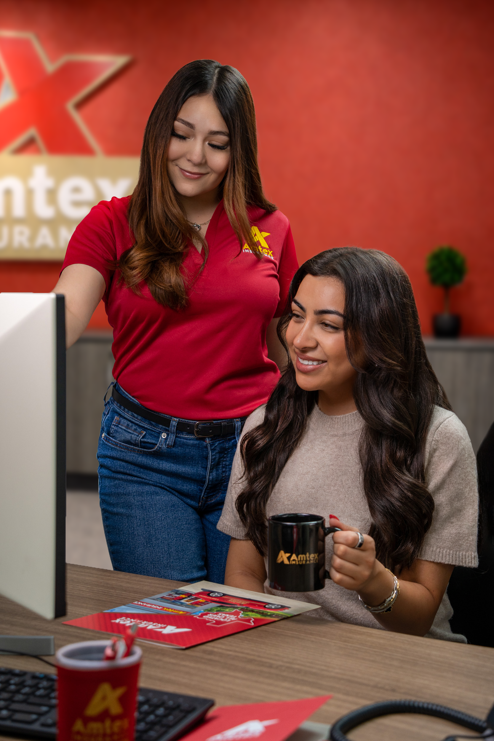 Amtex Insurance agent assisting a customer at a desk in a local office, reviewing insurance information together.